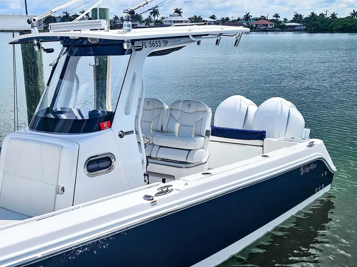  Yacht Photos Pics 2023 Edgewater 262CC boat docked on calm water, featuring dual engines and sleek design.