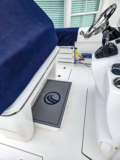  Yacht Photos Pics 2023 Edgewater 262CC boat interior with covered seating and steering wheel.