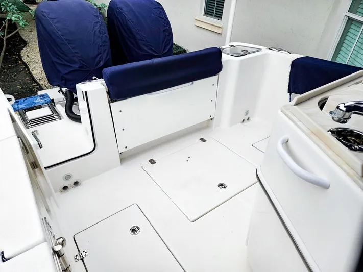  Yacht Photos Pics 2023 Edgewater 262CC boat interior with covered seats and storage compartments.