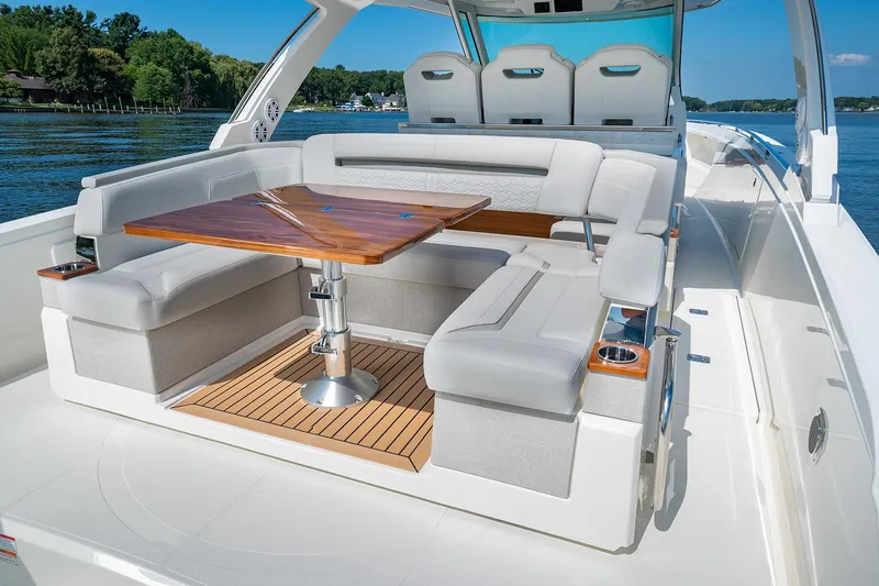Diamond Pearl Yacht Photos Pics Manufacturer Provided Image: 2024 Tiara Yachts 38 LS luxury boat exterior with seating and table on a sunny day.