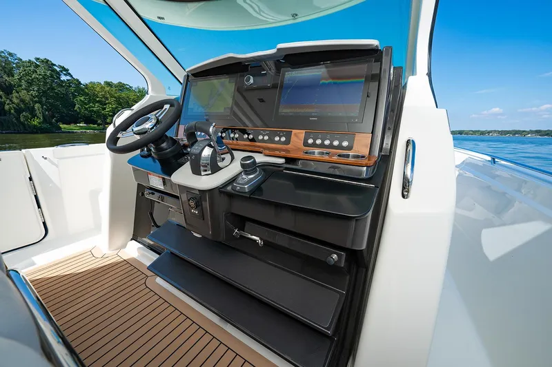  Yacht Photos Pics Manufacturer Provided Image: 2025 Tiara Yachts 38 LS helm with modern controls and dual screens, overlooking serene waters.