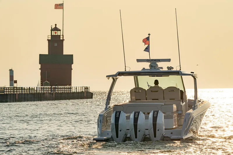  Yacht Photos Pics Manufacturer Provided Image: 2025 Tiara Yachts 38 LS cruising near a lighthouse at sunset.