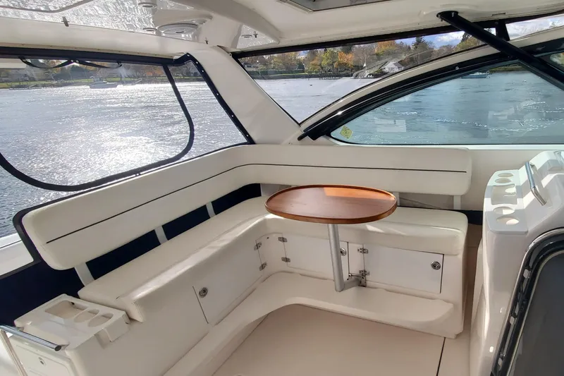 Cruse Yacht Photos Pics 2006 Tiara Yachts 4200 Open interior with white seating and wooden table by the water.