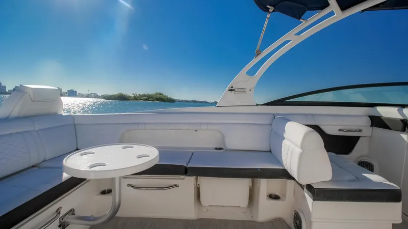 Finding Dori Yacht Photos Pics 2017 Sea Ray SDX 290 Outboard boat interior with white seating and table, under clear blue sky.