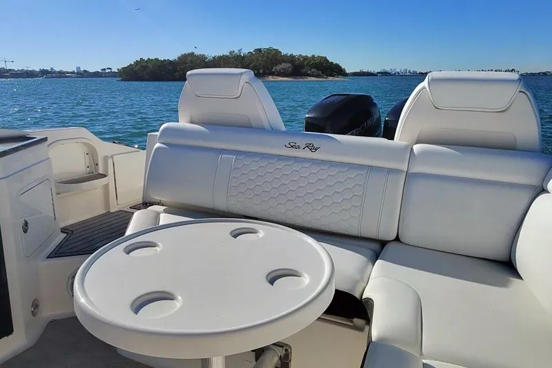 Finding Dori Yacht Photos Pics 2017 Sea Ray SDX 290 Outboard boat interior with seating and table, overlooking serene water.
