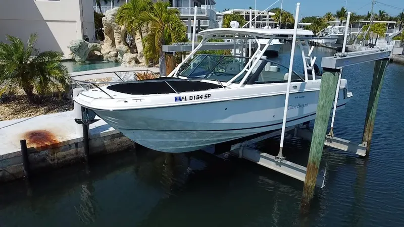  Yacht Photos Pics 2019 Boston Whaler 270 Vantage boat docked on a lift in a marina.