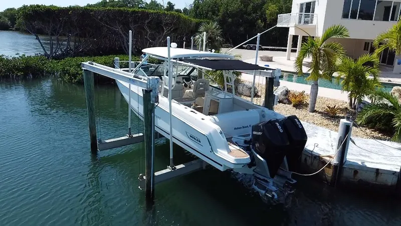  Yacht Photos Pics 2019 Boston Whaler 270 Vantage boat docked near waterfront home with lush greenery.