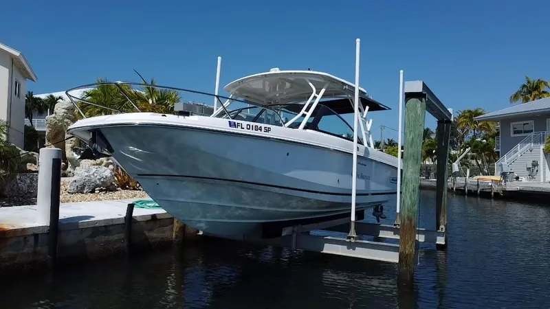  Yacht Photos Pics 2019 Boston Whaler 270 Vantage boat docked on a lift in a sunny marina.