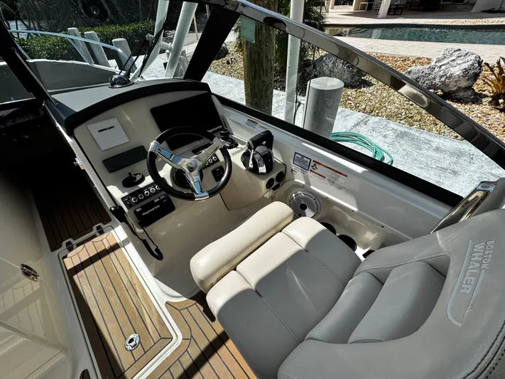  Yacht Photos Pics 2019 Boston Whaler 270 Vantage boat cockpit with steering wheel and seating.