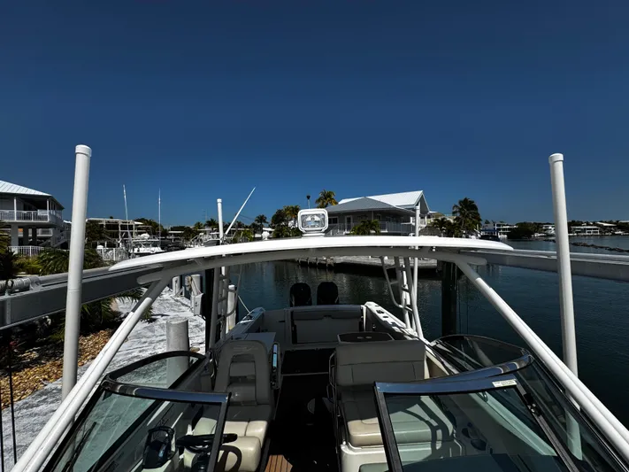  Yacht Photos Pics 2019 Boston Whaler 270 Vantage boat docked in a marina under clear blue skies.