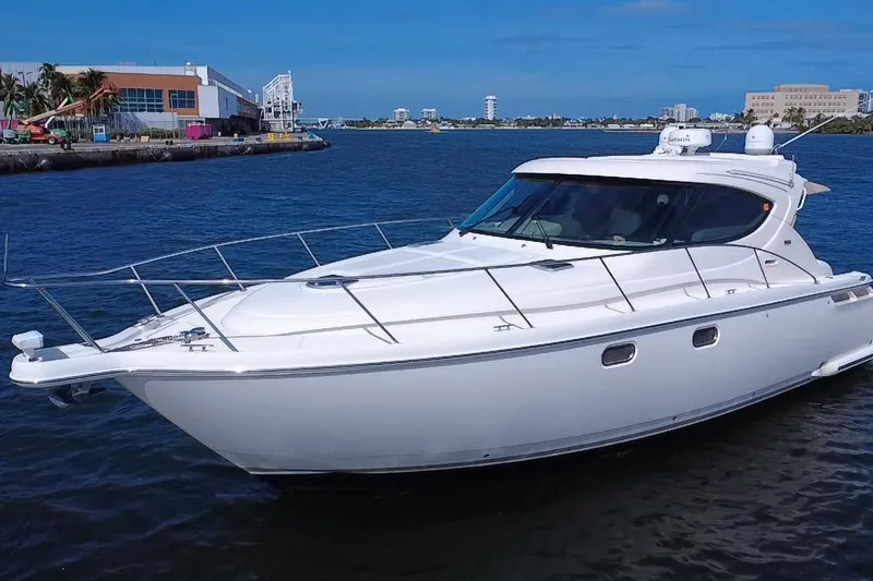  Yacht Photos Pics 2011 Tiara Yachts 4500 Sovran cruising in a marina under clear blue skies.