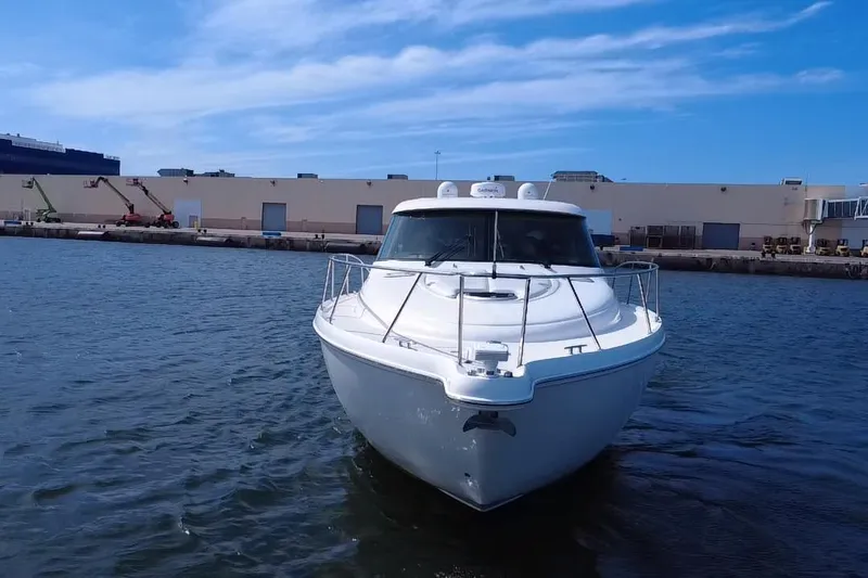  Yacht Photos Pics 2011 Tiara Yachts 4500 Sovran in marina, clear sky, industrial background.