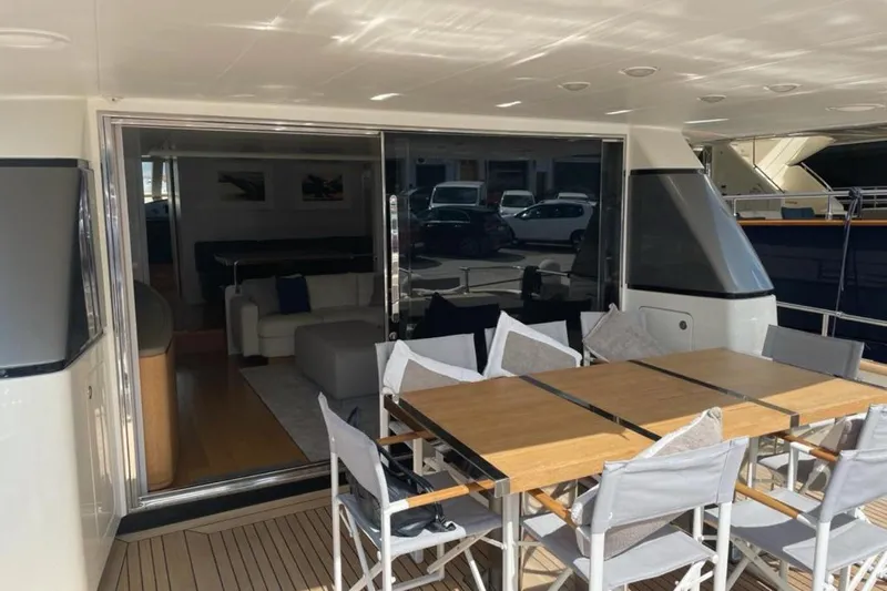  Yacht Photos Pics Outdoor dining area on 2010 Sanlorenzo SL72 yacht with wooden table and chairs.