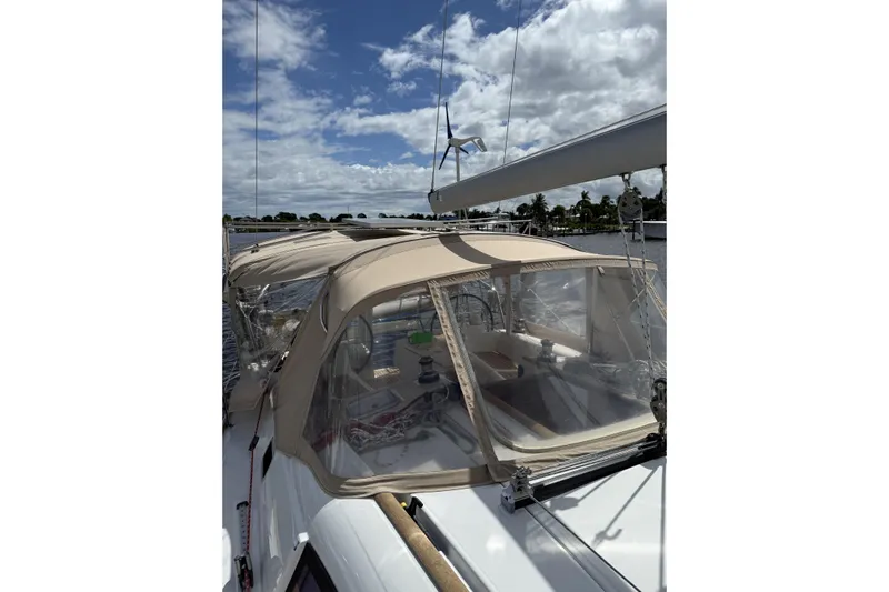 Vision 360 Yacht Photos Pics Beneteau First 435 sailboat, 2012 model, with beige canopy, docked under a partly cloudy sky.
