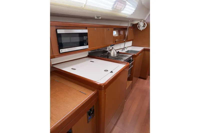 Vision 360 Yacht Photos Pics Modern kitchen interior of 2012 Beneteau First 435 yacht with wood finish and appliances.