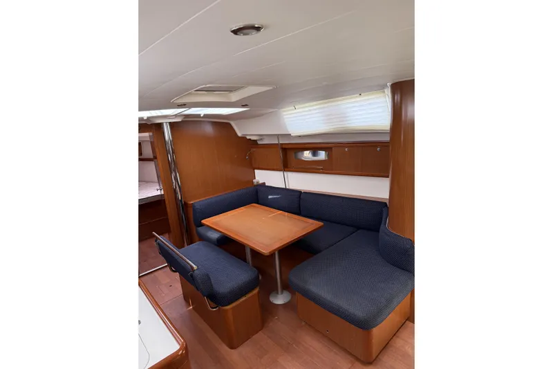 Vision 360 Yacht Photos Pics Interior of 2012 Beneteau First 435 sailboat with wooden dining area and blue seating.