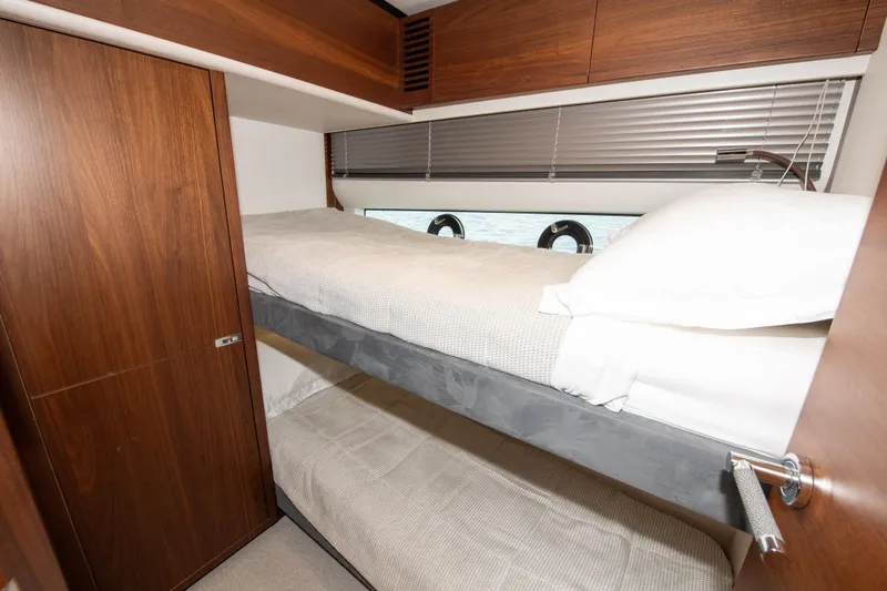 Wheelhouse Yacht Photos Pics Luxurious 2021 Princess S66 yacht cabin with wooden interior and cozy bunk beds.