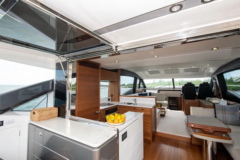 Wheelhouse Yacht Photos Pics Luxurious interior of 2021 Princess S66 yacht with modern kitchen and seating area.