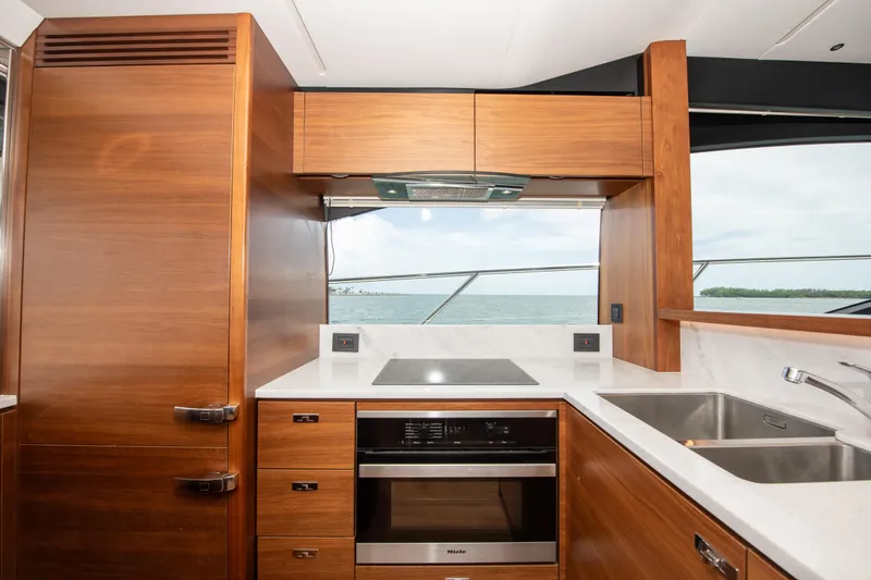 Wheelhouse Yacht Photos Pics Modern kitchen interior on 2021 Princess S66 yacht with wood cabinetry and ocean view.