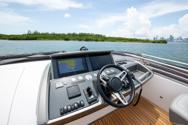 Wheelhouse Yacht Photos Pics Helm of 2021 Princess S66 yacht with navigation screens, steering wheel, and ocean view.