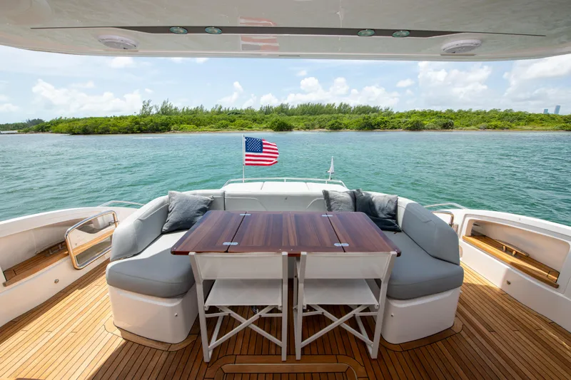 Wheelhouse Yacht Photos Pics Luxury yacht Princess S66 deck with seating, table, and American flag, 2021 model.