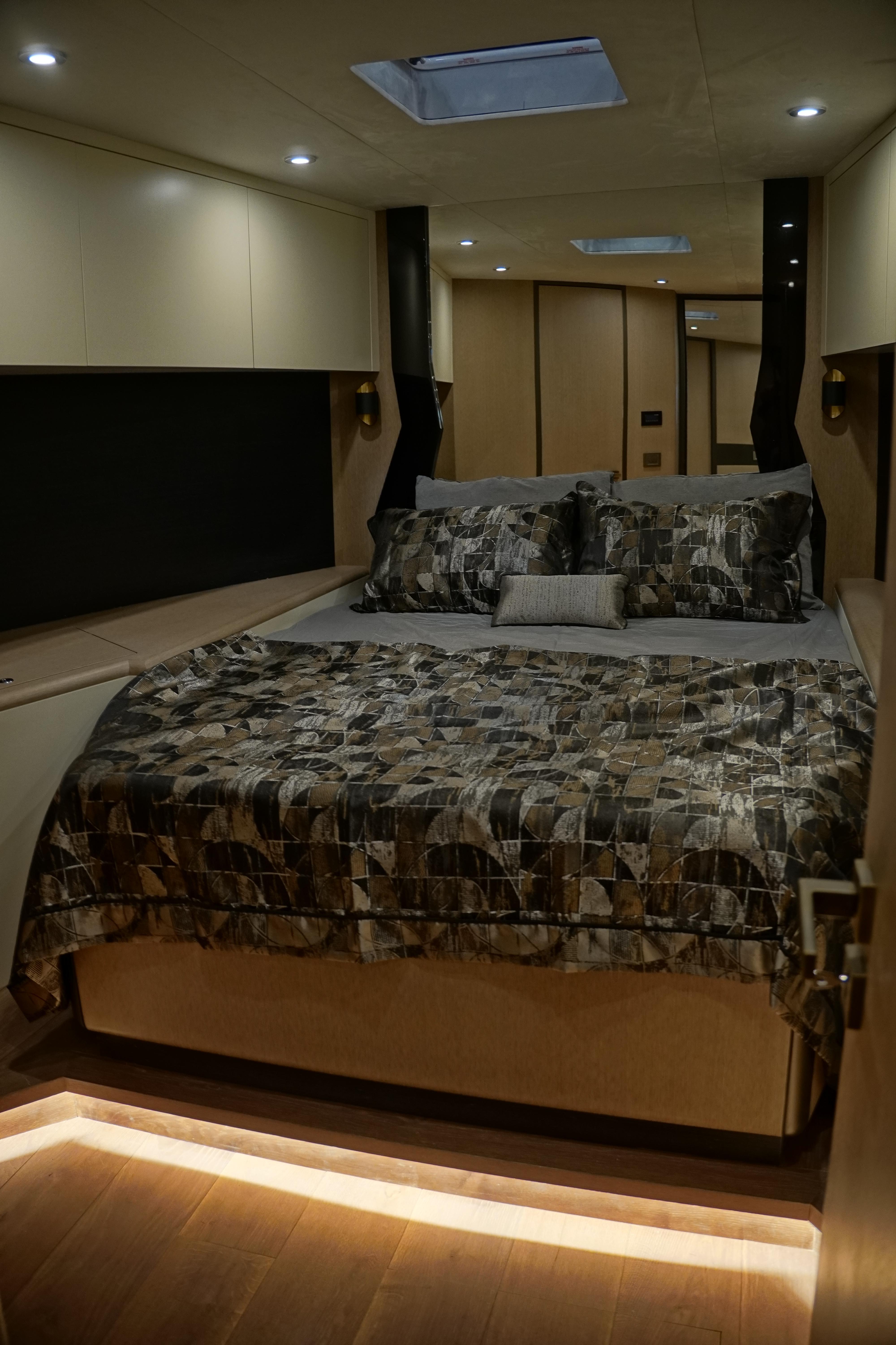 Luxurious bedroom in 2026 Phantom Spook Cabin Cruiser 62 yacht, featuring elegant bedding and ambient lighting.