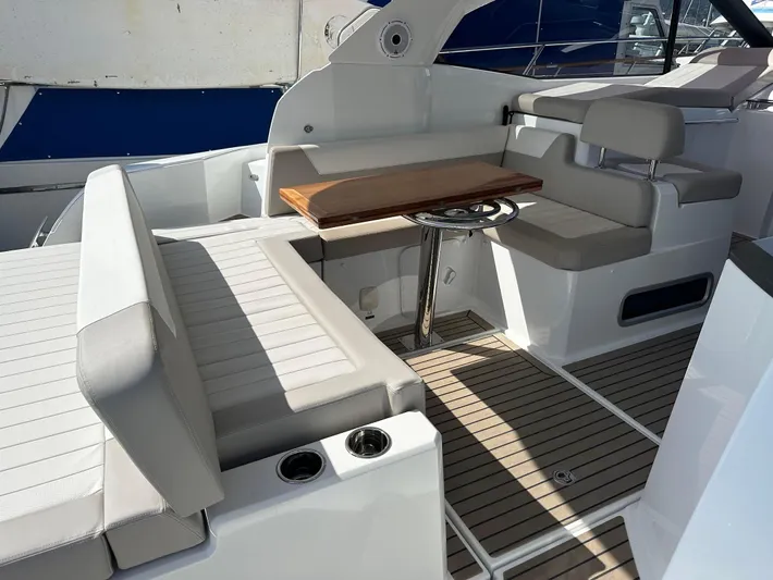 Le Bon Vie Yacht Photos Pics 2016 Jeanneau Leader 36 yacht interior with seating and wooden table.