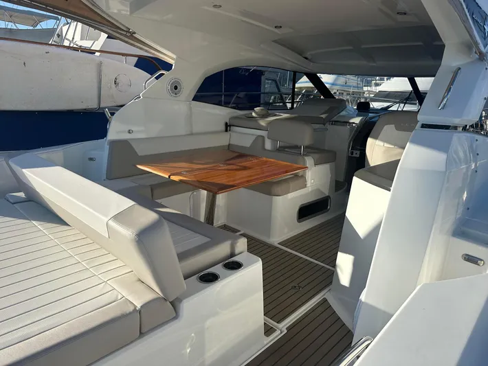 Le Bon Vie Yacht Photos Pics 2016 Jeanneau Leader 36 yacht interior with seating and wooden table.