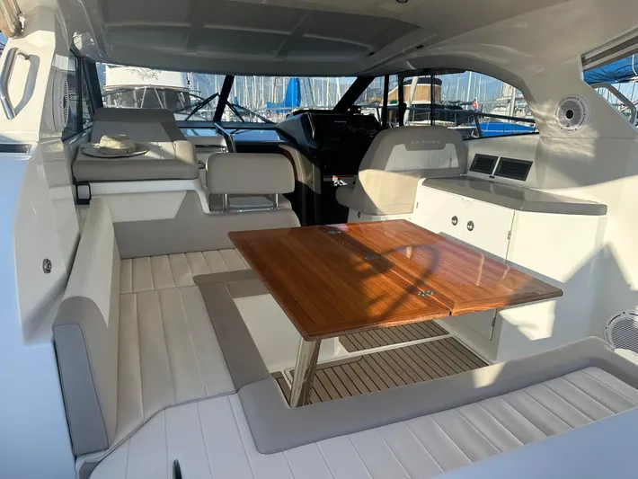 Le Bon Vie Yacht Photos Pics Interior of 2016 Jeanneau Leader 36 yacht with seating and wooden table.