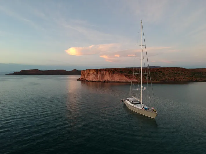 My Star Yacht Photos Pics Sailing yacht Alloy Yachts Sloop 1994 anchored near scenic coastal cliffs at sunset.