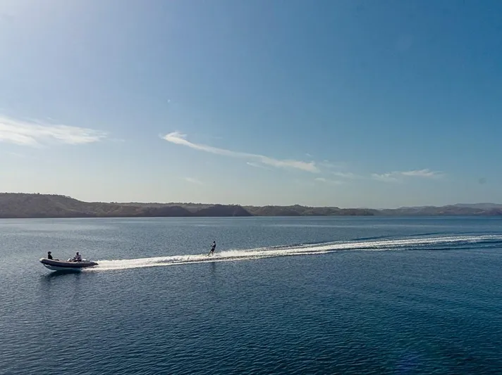 My Star Yacht Photos Pics Boat towing a water skier on a calm sea under a clear blue sky.