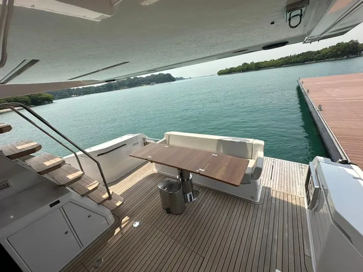  Yacht Photos Pics Luxurious 2023 Ferretti Yachts 500 deck with seating and scenic water view.