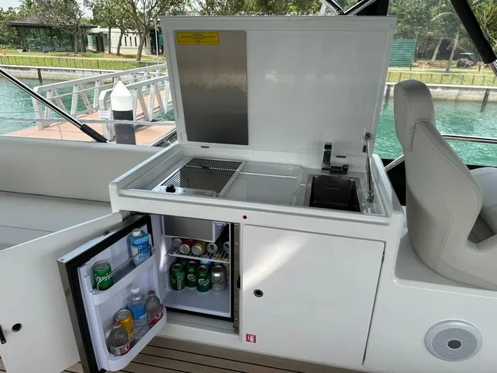  Yacht Photos Pics Outdoor kitchenette on 2023 Ferretti Yachts 500 with fridge and grill, dockside view.
