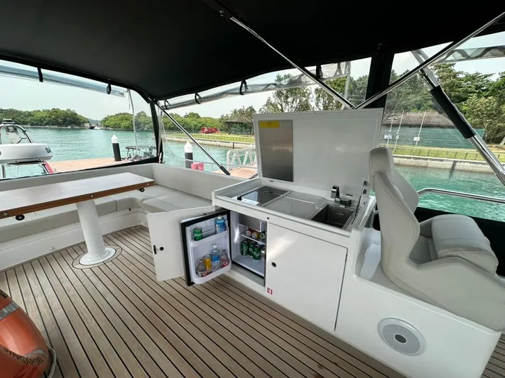  Yacht Photos Pics Luxurious 2023 Ferretti Yachts 500 deck with seating, kitchenette, and scenic water view.