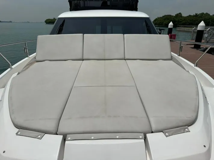  Yacht Photos Pics 2023 Ferretti Yachts 500 sun deck with cushioned seating, docked by the water.