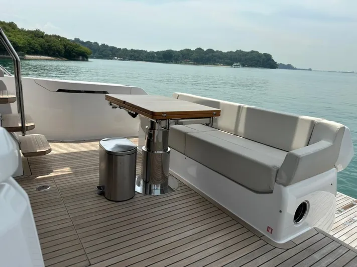  Yacht Photos Pics Luxurious 2023 Ferretti Yachts 500 deck with seating and table, overlooking serene waters.