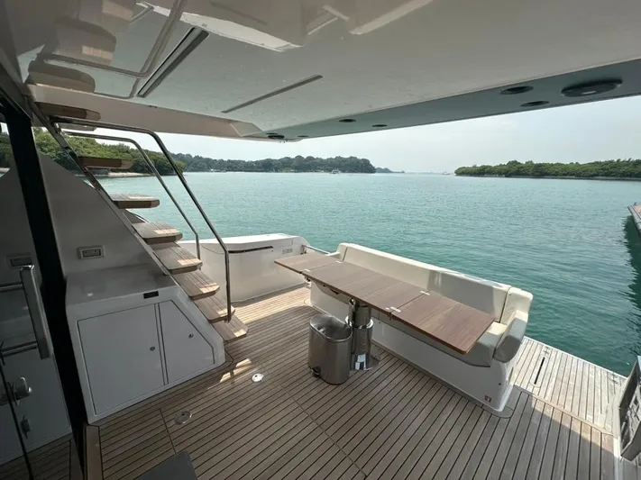  Yacht Photos Pics 2023 Ferretti Yachts 500 deck with seating, table, and scenic water view.