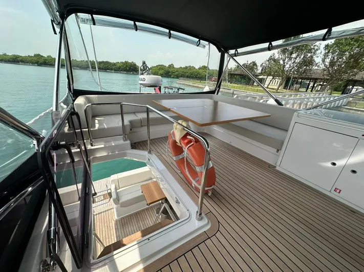  Yacht Photos Pics 2023 Ferretti Yachts 500 flybridge with seating, table, and scenic water view.