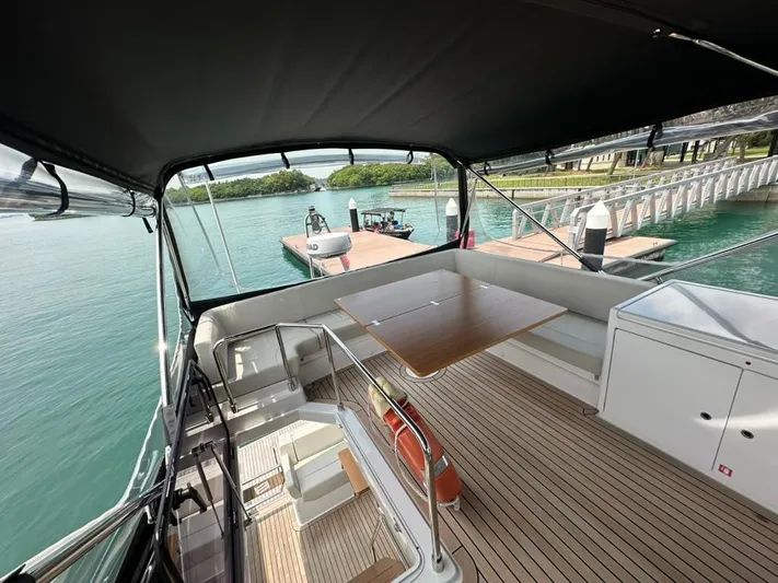  Yacht Photos Pics 2023 Ferretti Yachts 500, spacious deck with seating, docked by serene waters.