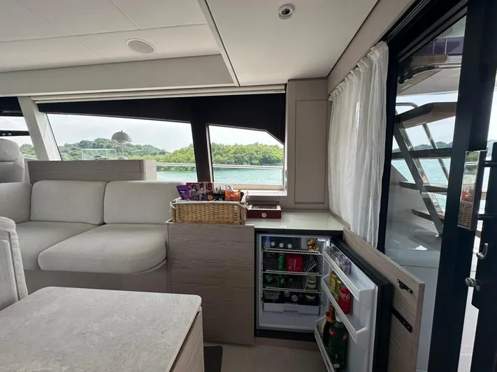  Yacht Photos Pics Luxurious interior of 2023 Ferretti Yachts 500 with open mini-fridge and scenic window view.