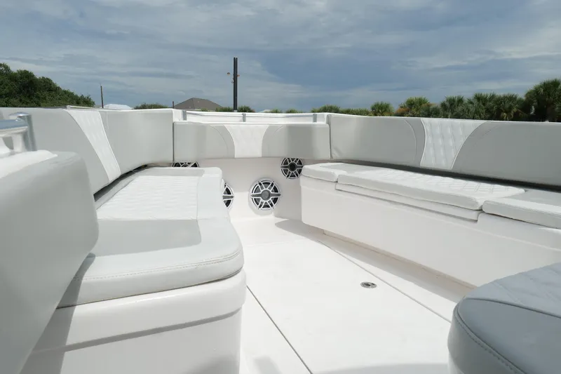  Yacht Photos Pics 2024 Contender 35 ST boat interior with white seating and speakers under a cloudy sky.
