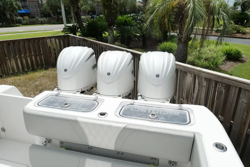  Yacht Photos Pics 2024 Contender 35 ST boat with triple Yamaha outboard engines, docked near palm trees.