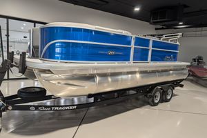 2026 Sun Tracker Party Barge 20 DLX pontoon boat on trailer in showroom.
