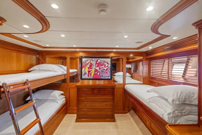 Drumbeat Yacht Photos Pics Luxurious wooden cabin interior on Alloy Yachts' 2002 Sailing Ketch DRUMBEAT, featuring bunk beds and artwork.