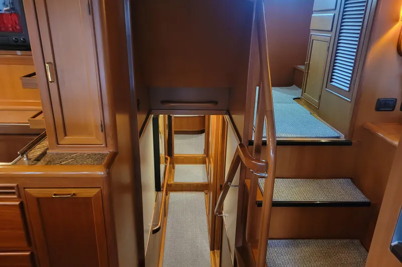 Miss Daisy Yacht Photos Pics Interior of 2005 Fleming Pilothouse yacht with wooden cabinetry and carpeted stairs.