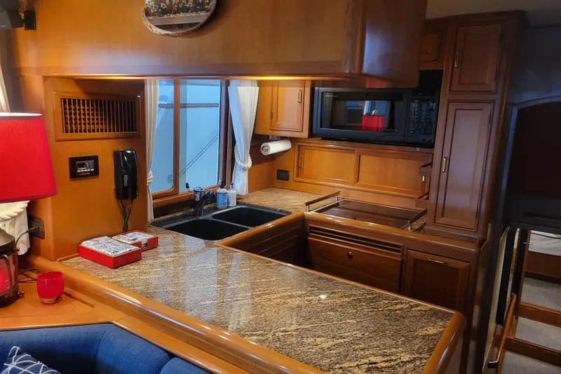 Miss Daisy Yacht Photos Pics Luxurious 2005 Fleming Pilothouse kitchen with granite countertops and wooden cabinetry.