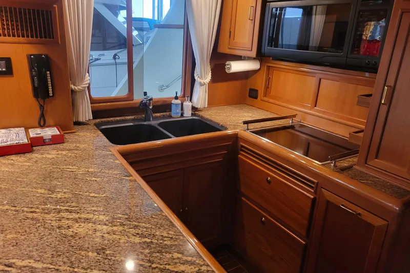 Miss Daisy Yacht Photos Pics Luxurious 2005 Fleming Pilothouse kitchen with granite countertops and wooden cabinetry.