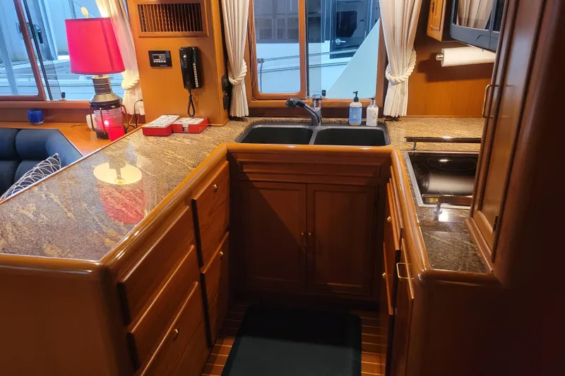 Miss Daisy Yacht Photos Pics Luxurious 2005 Fleming Pilothouse kitchen with granite countertops and elegant wood cabinetry.