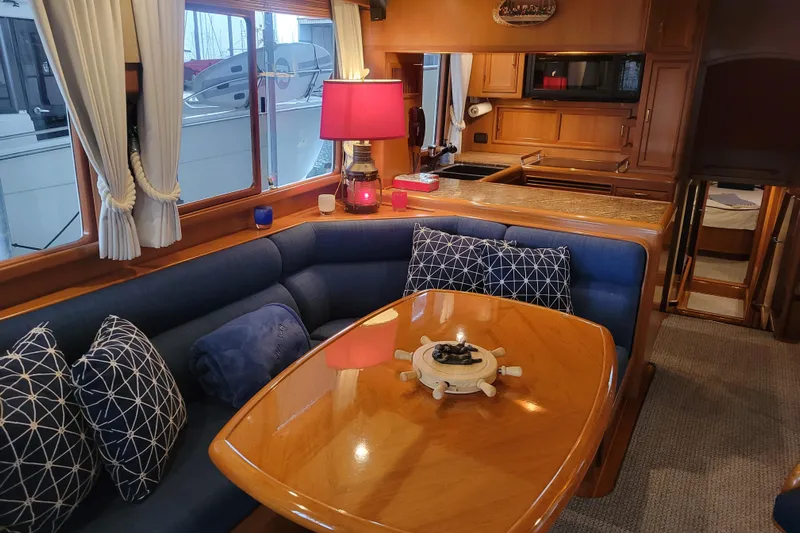 Miss Daisy Yacht Photos Pics Luxurious 2005 Fleming Pilothouse yacht interior with cozy seating and elegant wooden table.