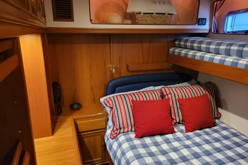 Miss Daisy Yacht Photos Pics Cozy cabin interior of 2005 Fleming Pilothouse with striped bedding and wooden accents.